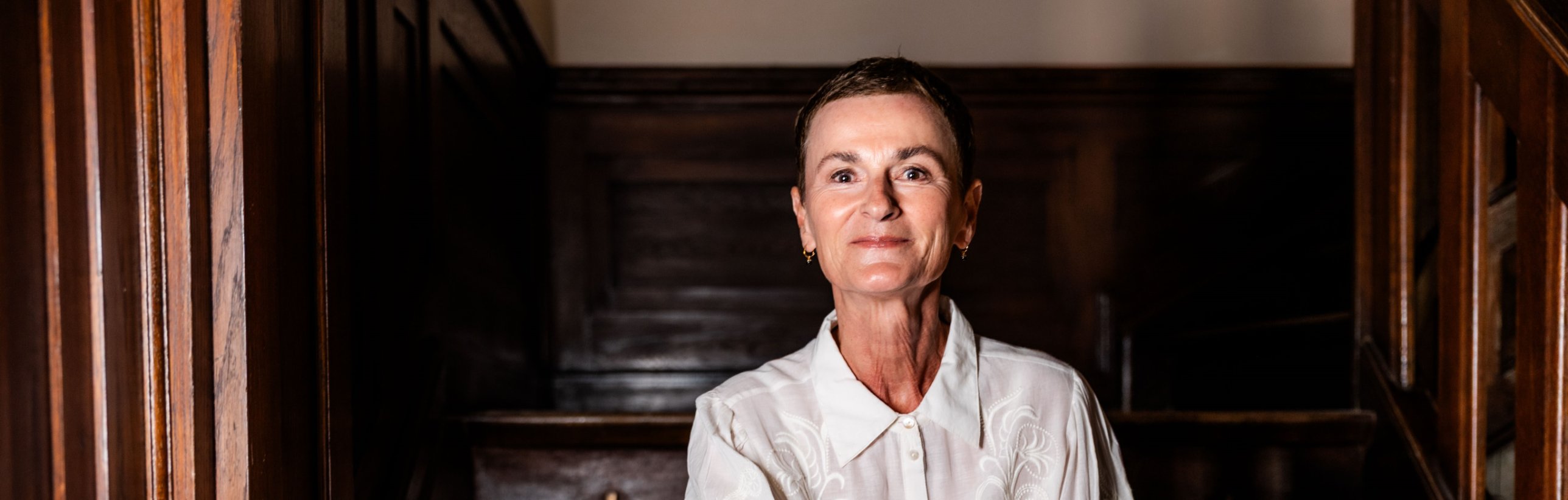 Ina Gerbsch, Expertin für Self-Leadership, auf einer dunklen Holztreppe